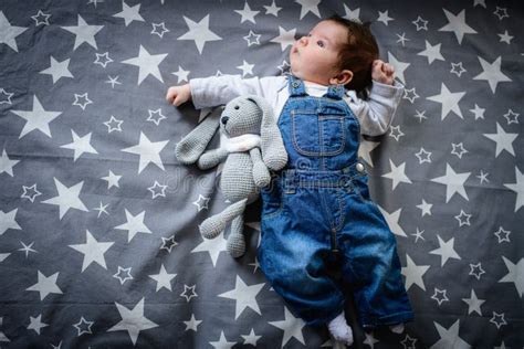 Baby With A Plush Toy In Bed Toy In The Form Of A Bunny Stock Photo