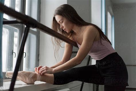 girl choreographer corrects ballet shoes in the hall by stocksy contributor demetr white