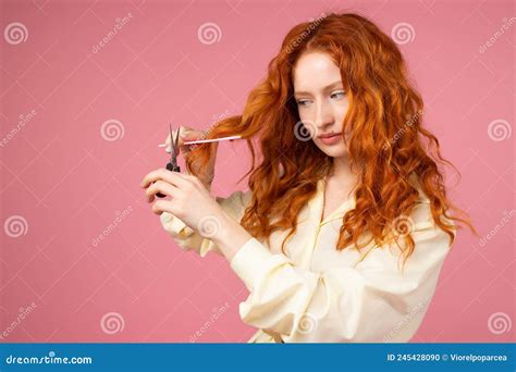 Photo Of A Pretty Redhead Young Woman With Curly Hair Holding Scissors And Hair Comb In Her