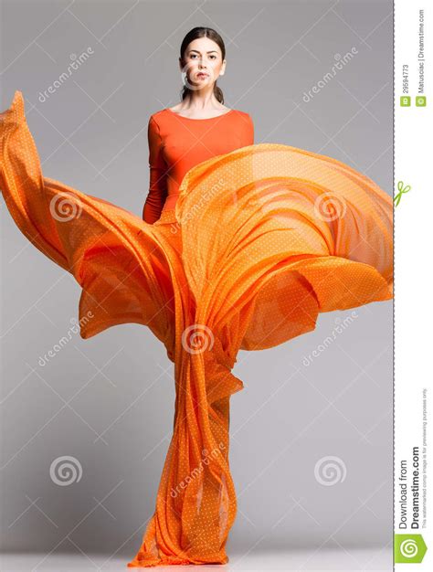 Beautiful Woman In Long Orange Dress Posing Dramatic Stock Image