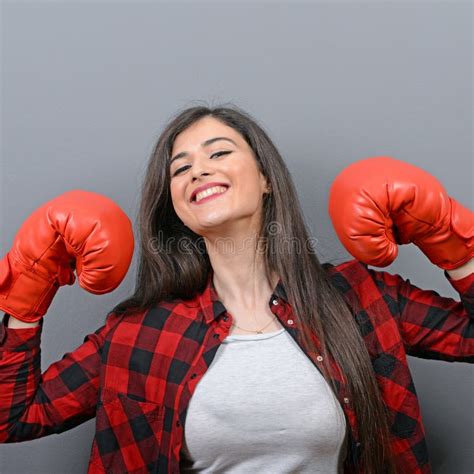 Portrait Of Young Woman Posing With Boxing Gloves Against Gray
