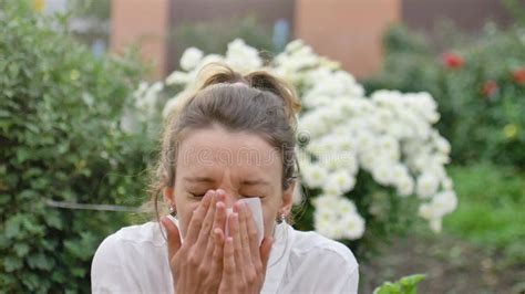 Girl Sneezes Into A Napkin Because She Is Allergic To Flowering During