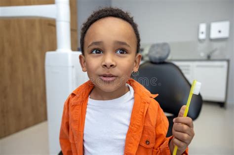 African American Boy Looking Involved While Brushing His Teeth Stock