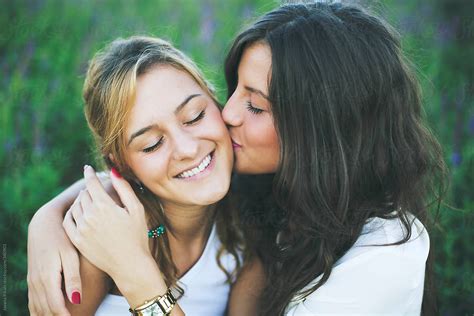 Two Young Female Friends One Kissing The Other On The Cheek By Stocksy Contributor Jovana
