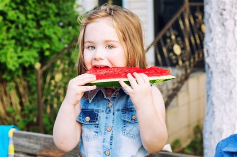 Premium Photo Little Girl Eating A Watermelon In The Garden