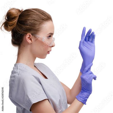Beautiful Female Doctor Or Nurse Wearing Protective Glasses Putting On