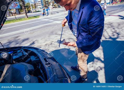 A Businessman Has Parked His Car At The Side Of The Boulevard While He
