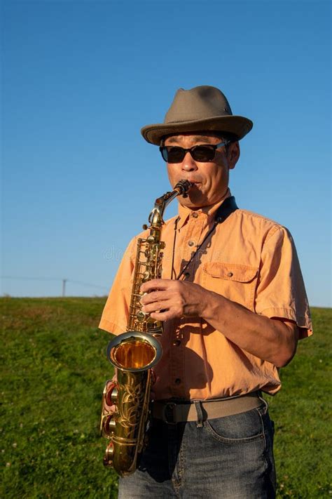 A Man Playing An Alto Saxophone At A Park Stock Image Image Of