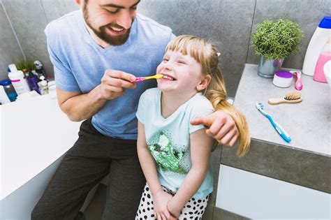 Free Photo Cheerful Father Helping Daughter To Brush Teeth