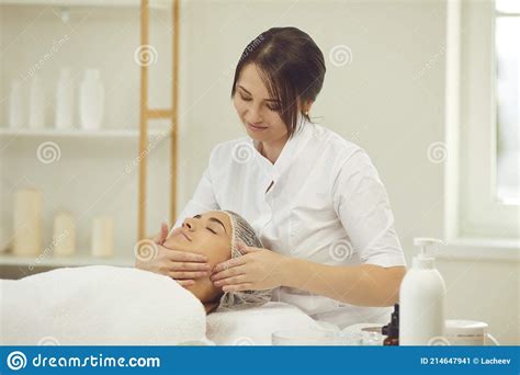 smiling woman dermatologist making manual relaxing facial massage for woman stock image image