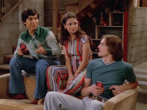 Three People Sitting On A Couch In A Living Room With One Person