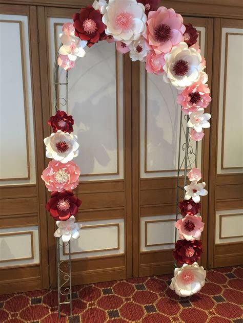 An Arch Made Out Of Paper Flowers On Display