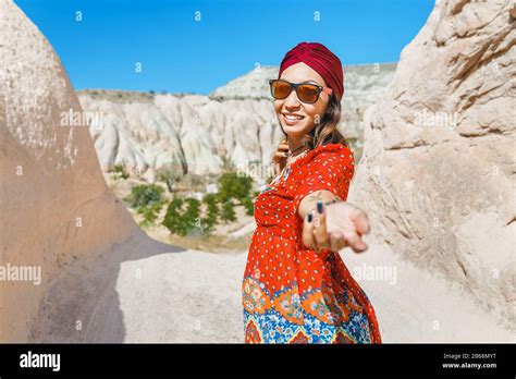 asian female traveler in the middle eastern desert in national dress with a turban follow me
