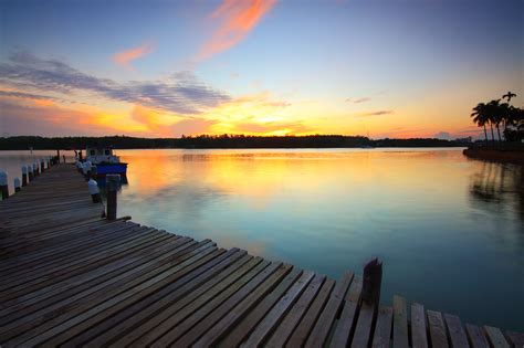 Brown Wooden Dock On Body Of Water During Twilight · Free Stock Photo
