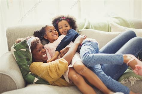 Playful Mother And Daughters Cuddling On Sofa Stock Image F0186443 Science Photo Library