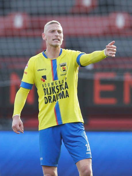 A Man In Yellow And Blue Soccer Uniform Pointing To The Sideline With