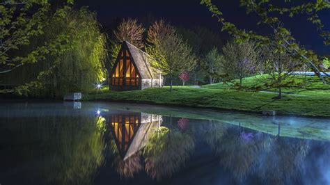 Beautiful House Reflection On Water Surrounded By Green Grass And Trees