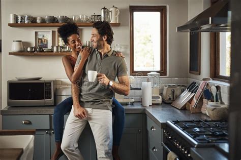 happy in love and laughing while an interracial couple enjoys morning coffee and bonding while
