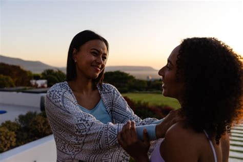 Premium Photo Biracial Lesbian Couple Embracing In Garden At Sunset Lifestyle Relationship