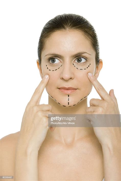 Woman With Plastic Surgery Markings On Face Touching Cheeks Looking