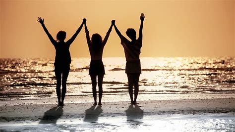Three Girls Celebrating The End Of Day With Sunset In Silhouette Stock