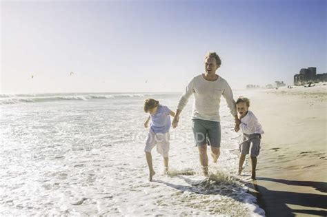 Padre E Hijos Tomados De La Mano En La Playa — Playa De Arena Etnia