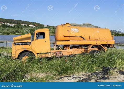Big Yellow Truck Parked On The Green Grass Near The Lake Stock Image