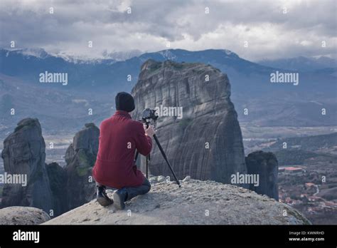 Traveler Man Photographer With Professional Camera And Tripod At The