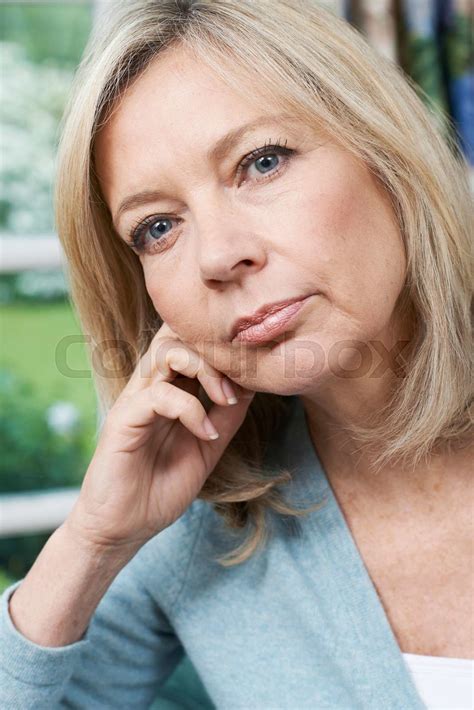 Head And Shoulders Portrait Of Thoughtful Mature Woman At Home Stock