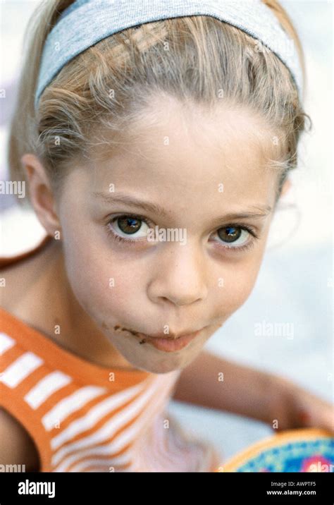 Little Girl With Chocolate On Face Looking Into Camera Portrait Stock