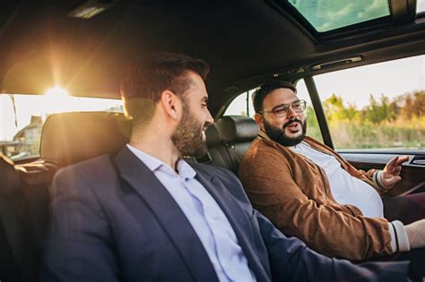 Two Men Driving On The Backseat Stock Photo Download Image Now Car