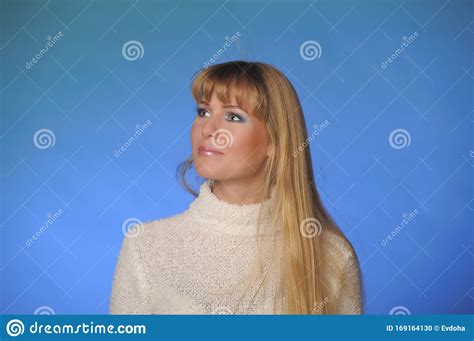Portrait Of A Beautiful Long Haired Blonde In A Studio On A Blue