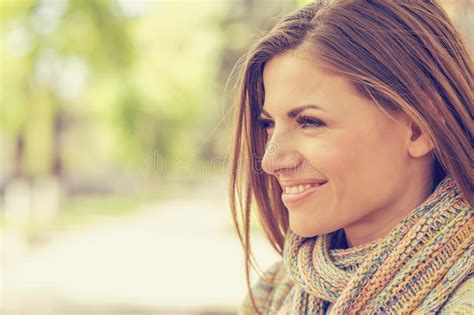 retrato de uma mulher de sorriso em um parque que olha afastado imagem de stock imagem de