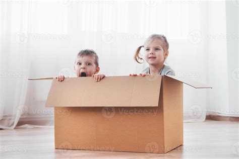 Dos Niños Pequeños Niño Y Niña Jugando En Cajas De Cartón Foto De