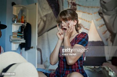 Girl Sitting On Bed Making Funny Face While Trying Glasses Photo