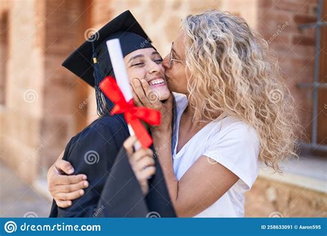 two women mother and graduated daughter hugging each other at campus university stock image