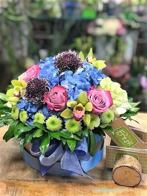 Your personal message will be displayed on an attractive greeting card. Happy new life - Flower arrangement in a designed hat box ...