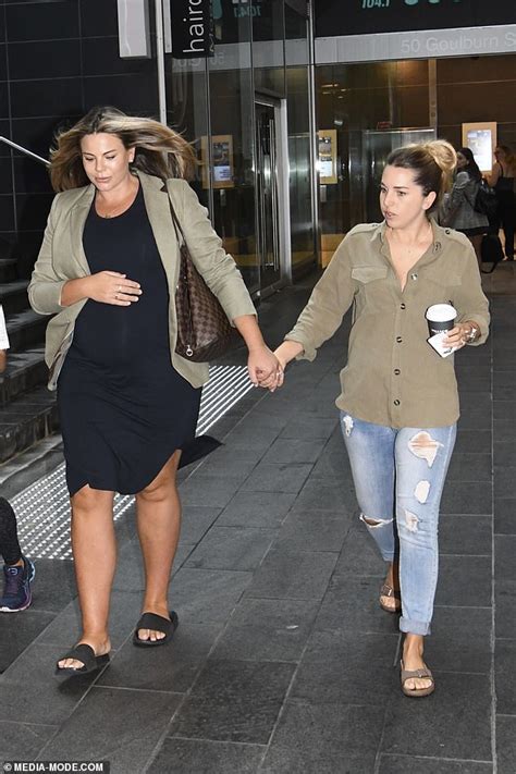 heavily pregnant model fiona falkiner walks hand in hand with her fiancée hayley willis in