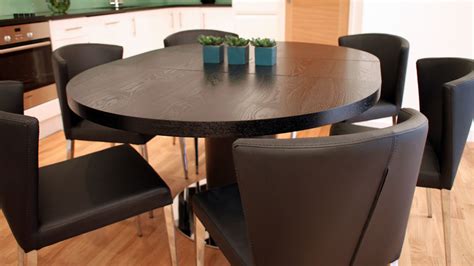 A dining table in e.g. Black Ash Round Extending Dining Table | Pedestal Base | UK