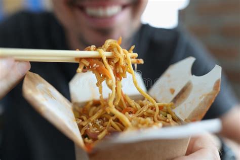 Smiling Man Eating Spicy Noodle Chinese Food With Vegetable Using