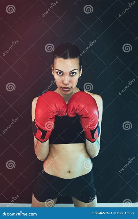 Hold Nothing Back A Young Woman Wearing Boxing Gloves Against A Dark