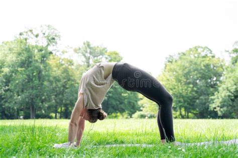 Young Fit Woman Doing Backbend Push Ups Yoga Wheel Pose In Sunny Summer