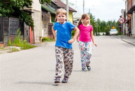 Two Smiling Little Girls Walking On The Street Happy Siblings Stroll