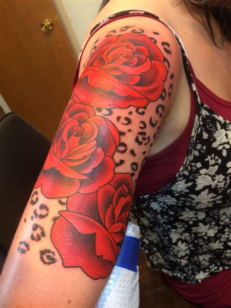 A Womans Arm With Red Roses And Leopard Print On The Sleeve Which Is