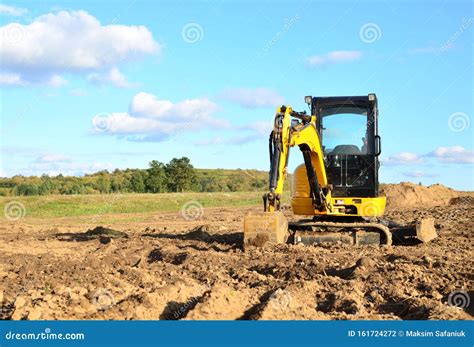 Mini Excavator Digging Earth In A Field Or Forest Editorial