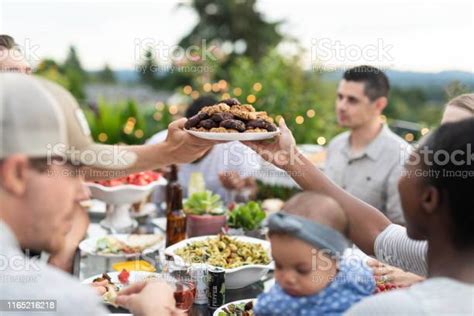 A Group Of Young Adult Friends Dining Al Fresco On A Patio Stock Photo