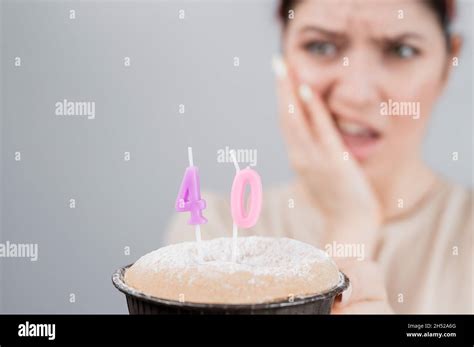 unhappy woman holding a cake with candles for her 40th birthday the girl cries about the loss