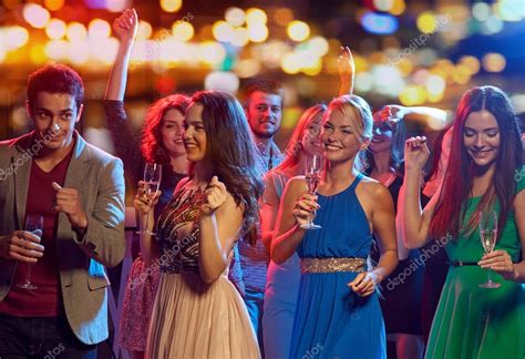 Happy Friends With Champagne Dancing At Nightclub Stock Photo Syda