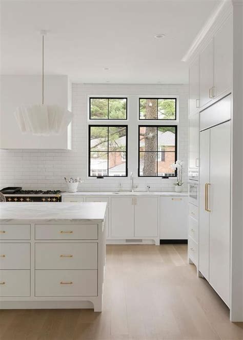 Stacked White Flat Front Doors Fitted With Brass Pulls Accent A Kitchen