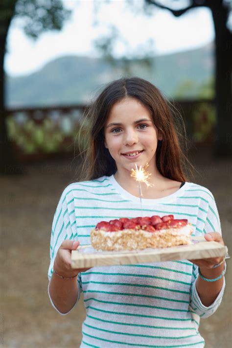 «Cute Young Girl Carrying A Birthday Cake» del colaborador de Stocksy